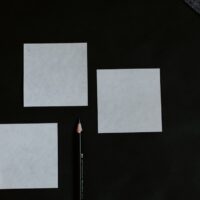 A black table topped with a pencil and paper