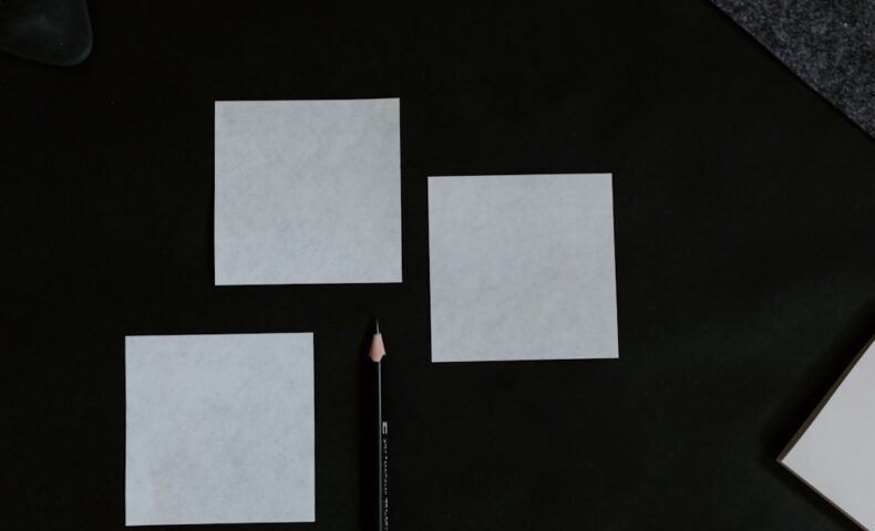 A black table topped with a pencil and paper