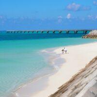 a beach with people walking on it