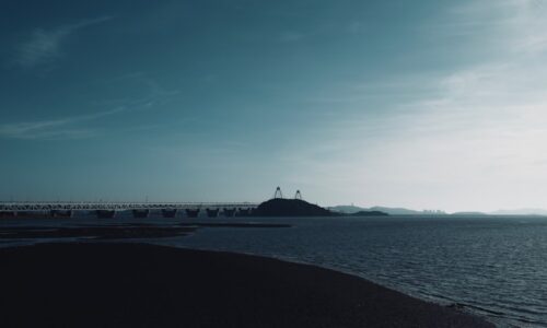 a large body of water with a bridge in the background