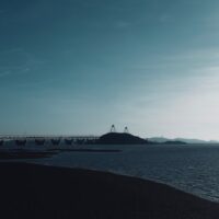 a large body of water with a bridge in the background