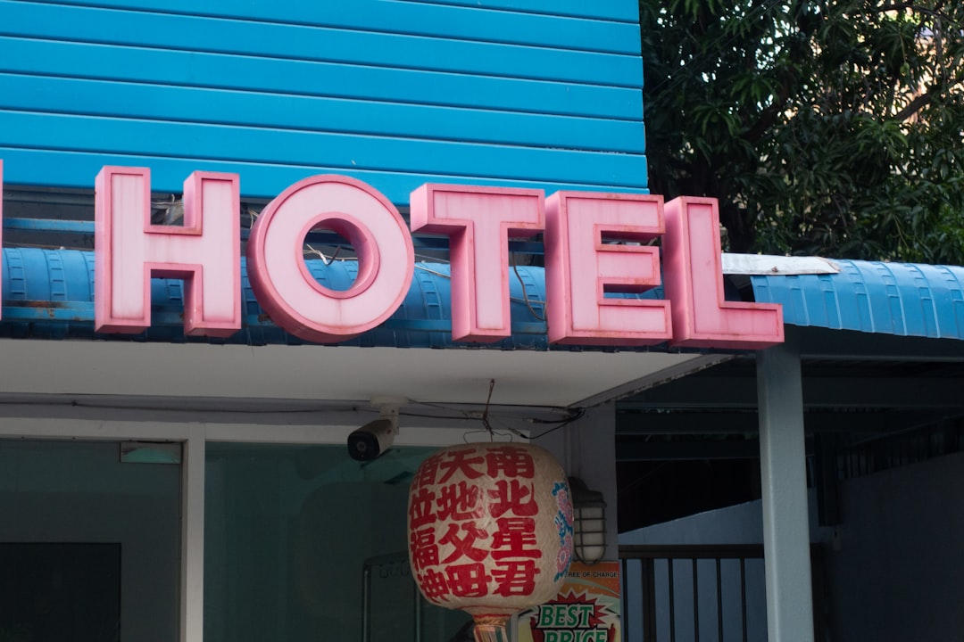 a blue building with a neon sign that says hotel
