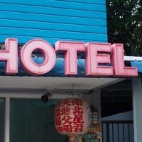 a blue building with a neon sign that says hotel