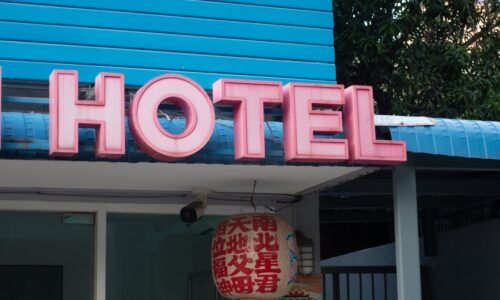 a blue building with a neon sign that says hotel