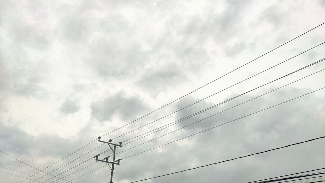 a telephone pole and power lines against a cloudy sky