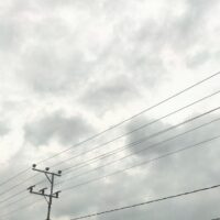 a telephone pole and power lines against a cloudy sky