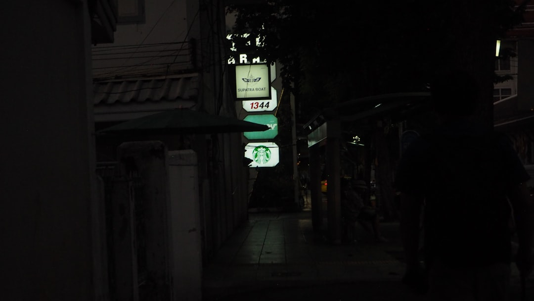 A dark alley way with a green street sign