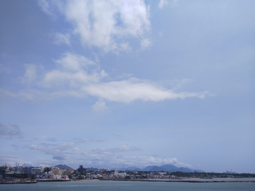 a body of water with buildings and mountains in the background